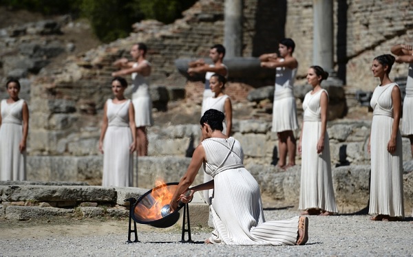 Ино Менегаки в роли Верховной жрицы богини Геры зажигает факел при помощи параболического зеркала