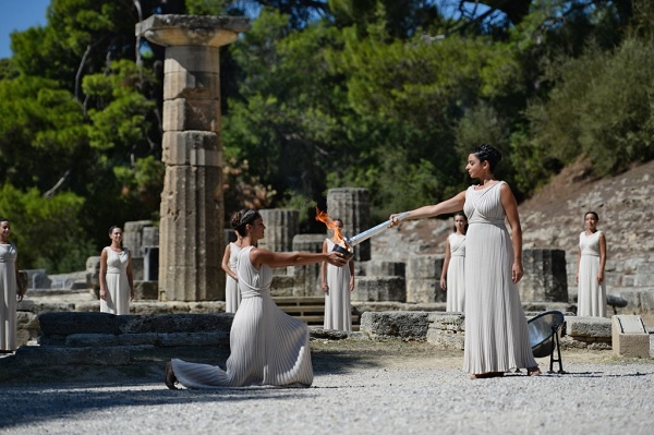 Ино Менегаки в роли Верховной жрицы богини Геры (справа) с факелом Олимпийского огня